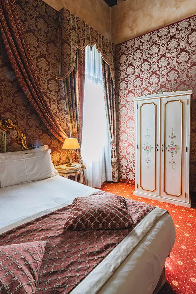 Web Marketing per Hotel — Junior Suite vista canale del Boutique Hotel Ca'Amadi a Venezia con arredi del '700 colori rosso e oro