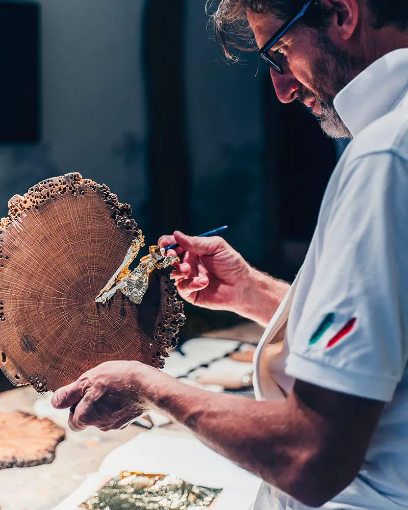 Creazione contenuti visivi — Sebastiano Lunardelli mentre decora uno Sfojo in legno di bricola