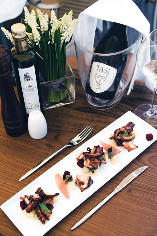 Creazione contenuti visivi — Piatto gourmet a base di pesce con bottiglia di prosecco su tavolo in legno Ristorante al Theatro